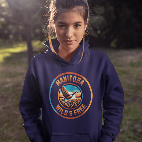 Celebrate the heart of the prairies with our Manitoba – Wild & Free hoodie, featuring a stunning graphic of a Canadian goose soaring over golden wheat fields.
